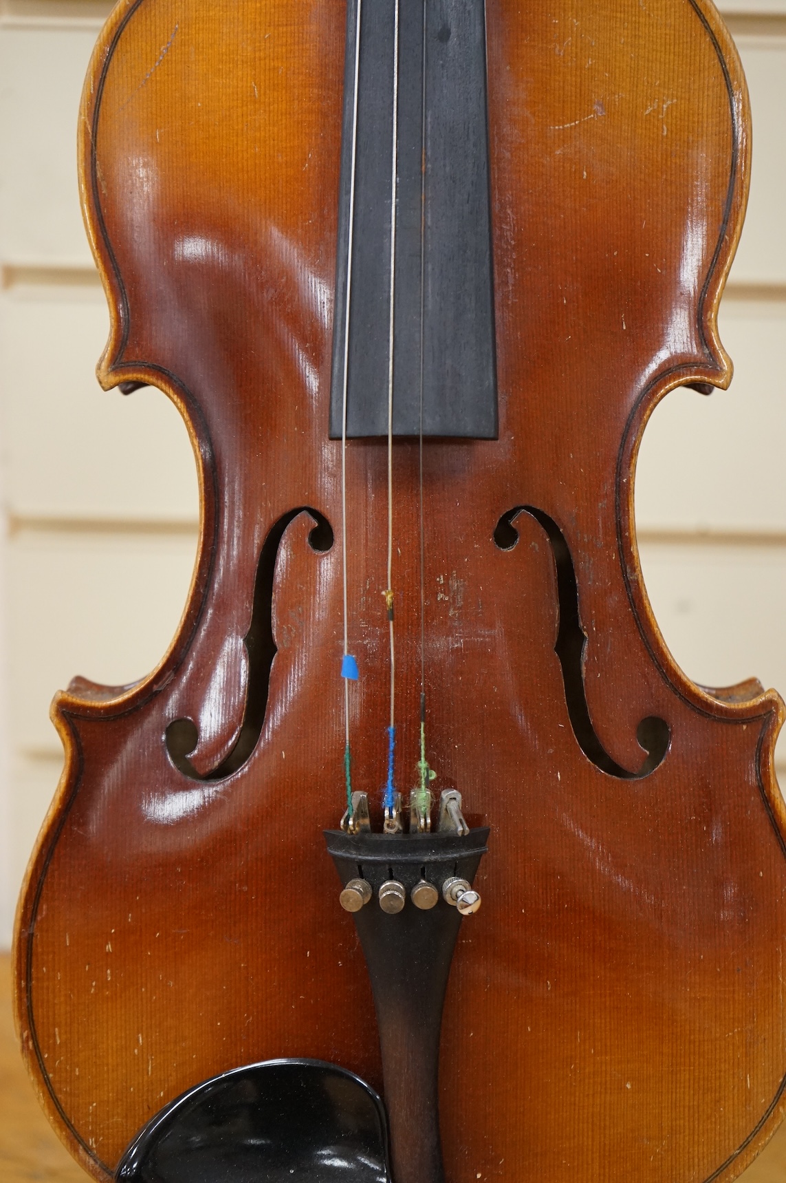 Five cased 20th century violins, including; a German violin, two Czech violins, a three-quarter size violin with a label for Bienfait, and a Romanian quarter size violin, all in cases or the remains of cases.